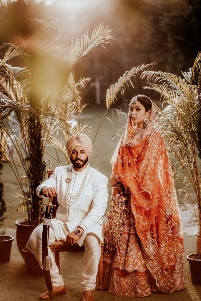 Elegant shot of a couple in traditional attire at an outdoor Indian wedding ceremony.