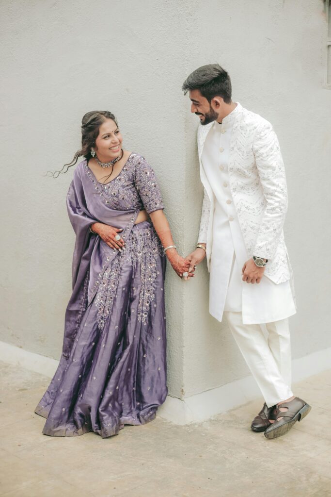 Happy Indian couple holding hands in traditional wedding attire, radiating joy and love.